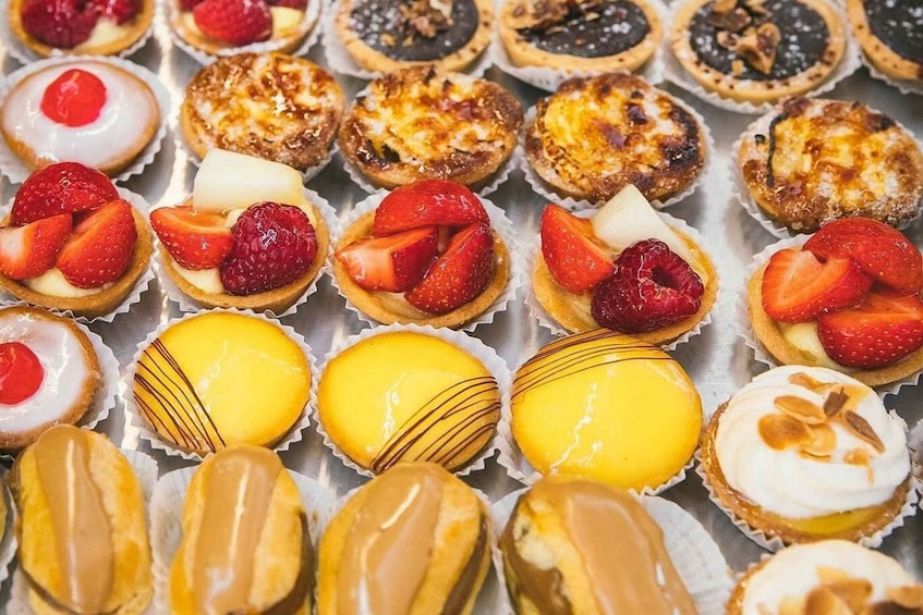 A variety of pastries and desserts in individual paper cups. 1