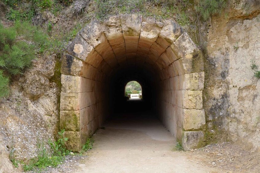 A stone tunnel with a pathway leading through it. 2