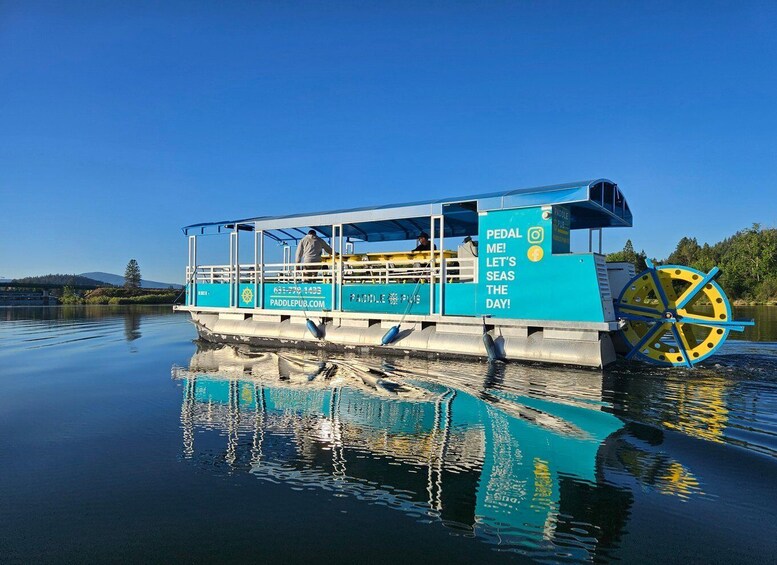A paddle boat with a wheel and text advertising a pedal-powered pub service. 4
