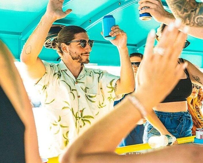 A group of people in a casual setting, possibly a party or gathering, with one individual holding a blue cup. 5
