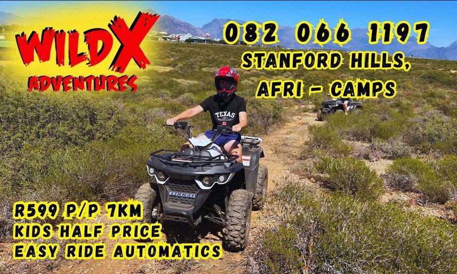 A person riding an ATV on a dirt trail in a natural landscape with mountains in the background. 1