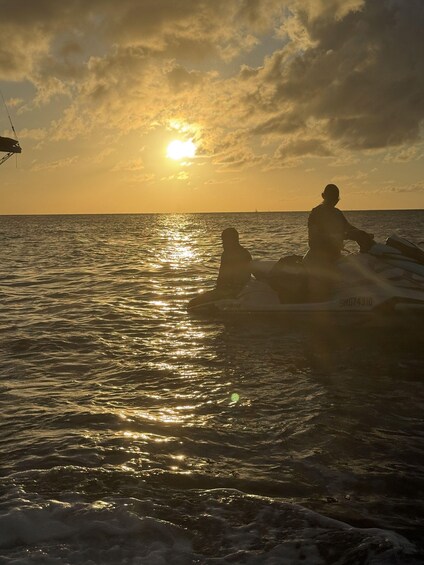 Two people on a jet ski in the ocean at sunset. 3
