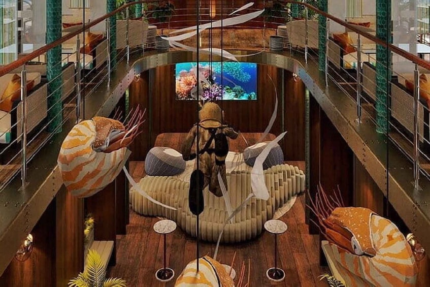 A circular aquarium with a central viewing area, surrounded by seating and decorative elements. 1