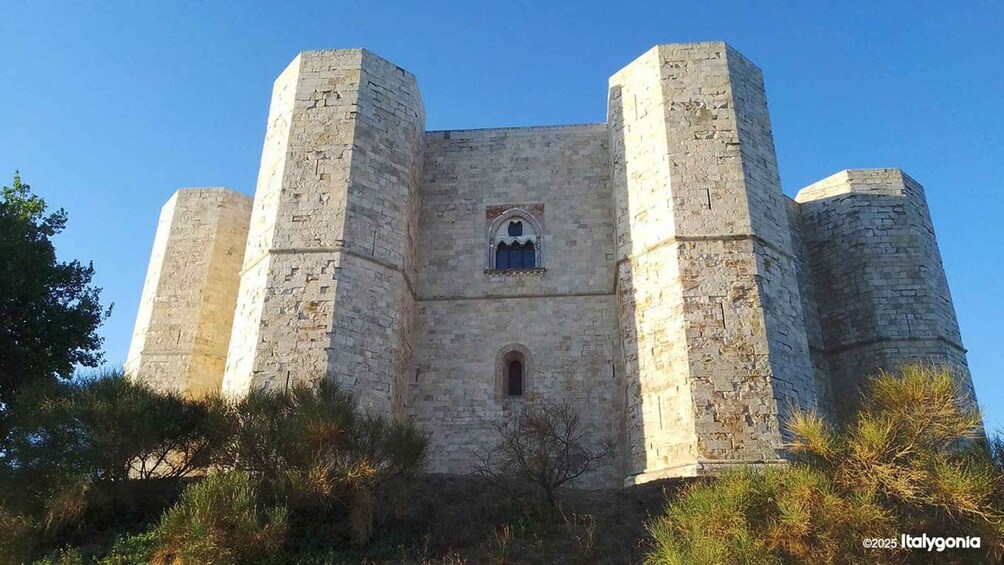 A medieval castle with four towers and a central arched window. 1