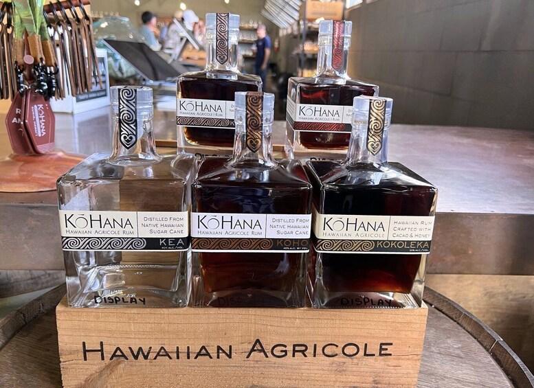 A display of KOHANA Hawaiian Agricole Rum bottles on a wooden stand. 5