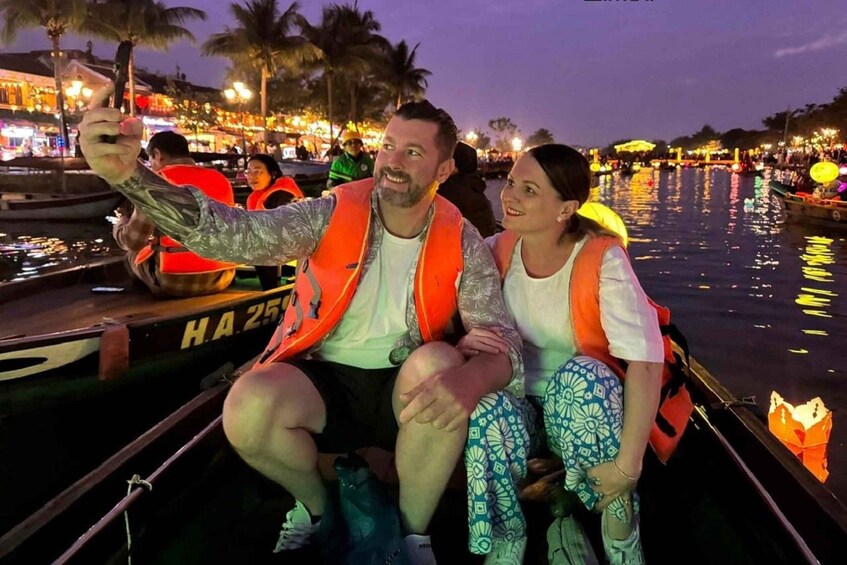 Two people on a boat with a cityscape and water in the background. 2