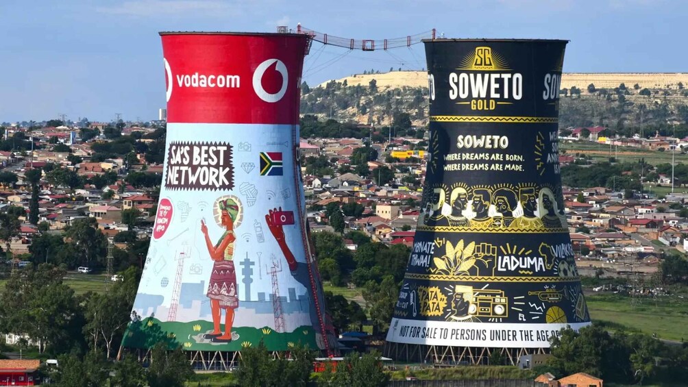 Kaksi suurta, sylinterinmuotoista mainostaulua, joissa on Vodacomin ja SOWETO GOLDin mainoksia. 3