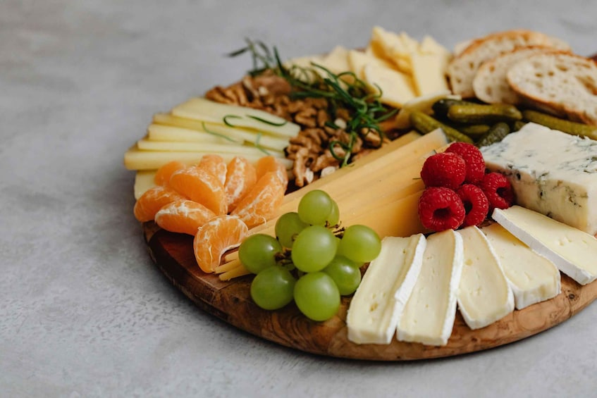 A charcuterie board with various cheeses, fruits, and nuts. 3