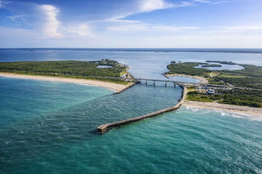 A coastal landscape with a bridge connecting two landmasses over a body of water. 1