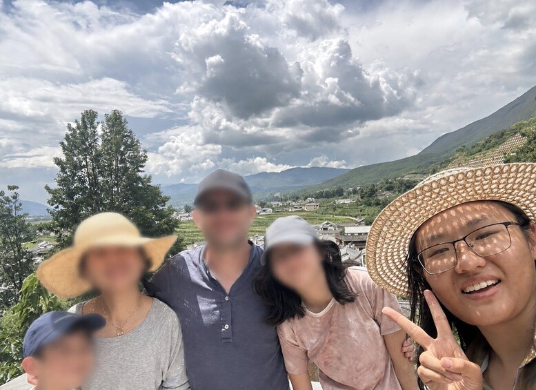 A group of people in a mountainous landscape with a cloudy sky. 2
