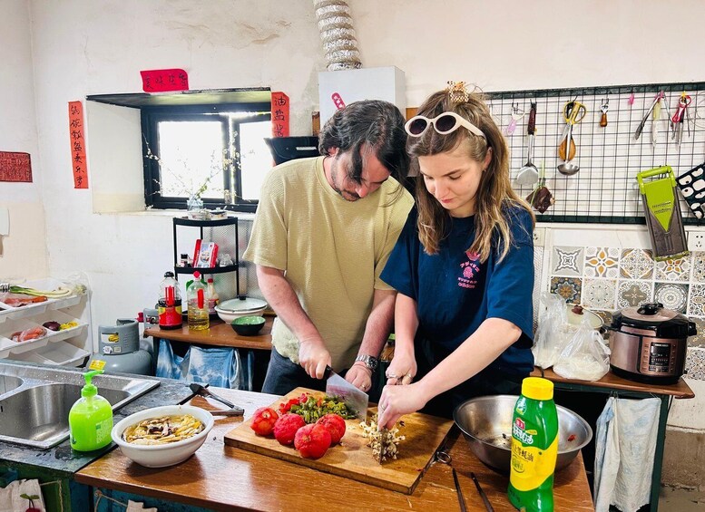 Two people preparing food in a kitchen with various cooking utensils and ingredients. 4