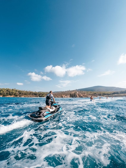 A person jet-skiing on a body of water with a mountainous landscape in the background. 4