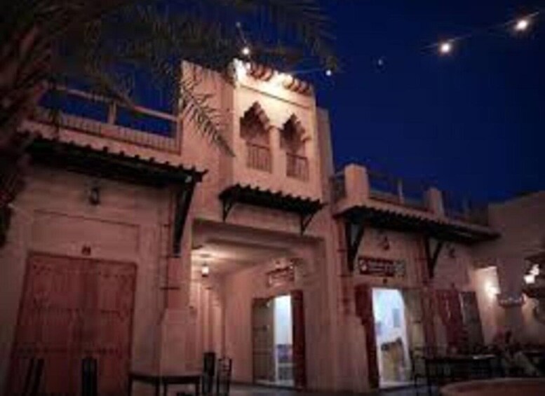 A traditional building with arched windows and a tiled roof, surrounded by palm trees. 2