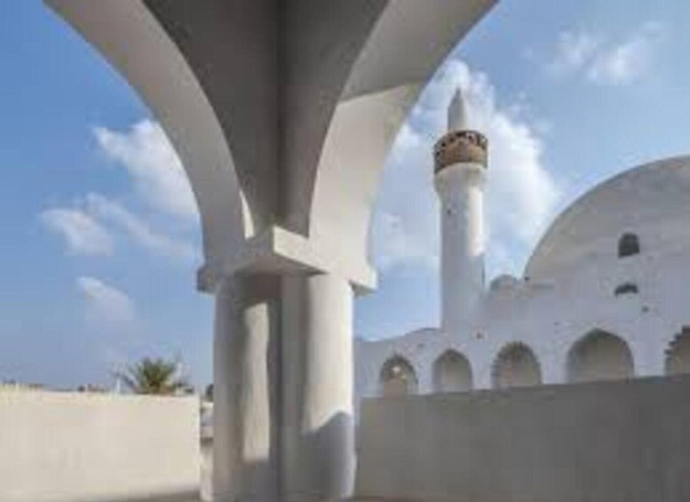 A mosque with a minaret and arches. 4