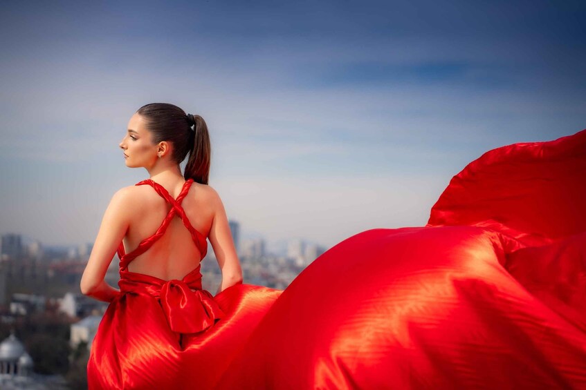 A person in a red dress with a cityscape in the background. 3