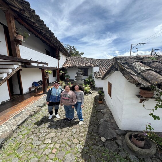 A traditional courtyard with stone paving, white walls, and tiled roofs. 5