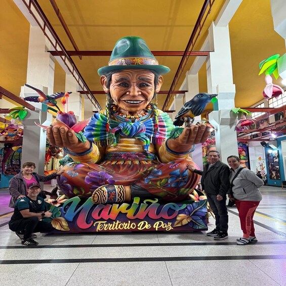 A colorful mural of a man with a hat and birds, surrounded by people. 3