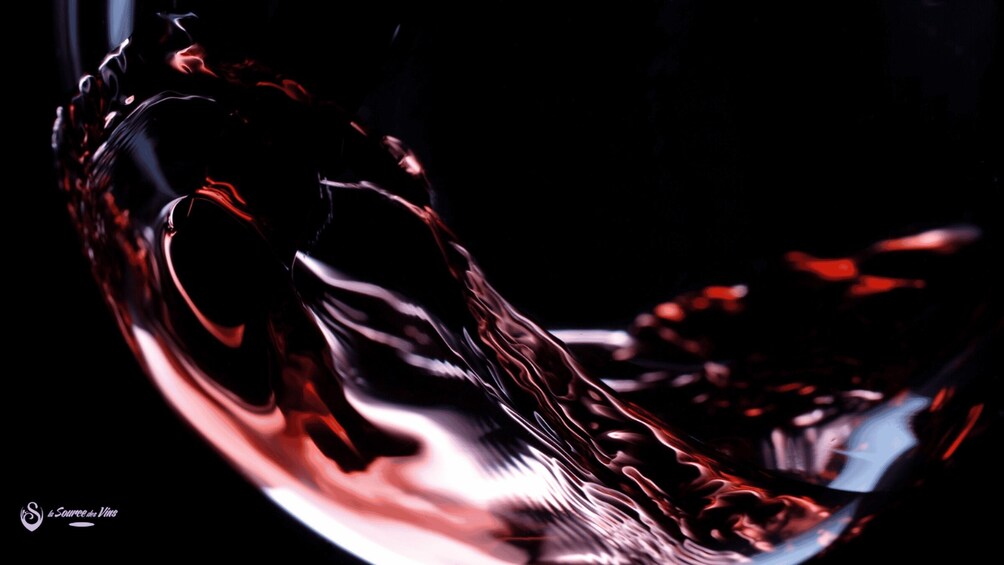 A close-up of a glass of red wine with a dark background. 3