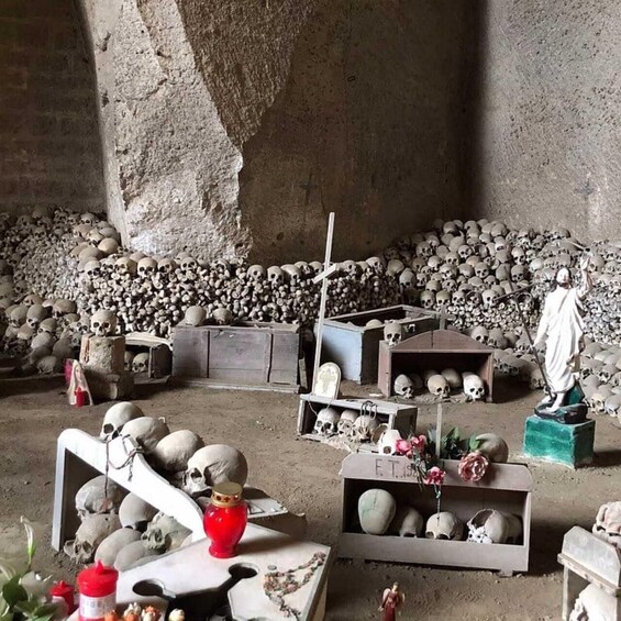 A room filled with skulls, some with crosses, and a figure standing. 4