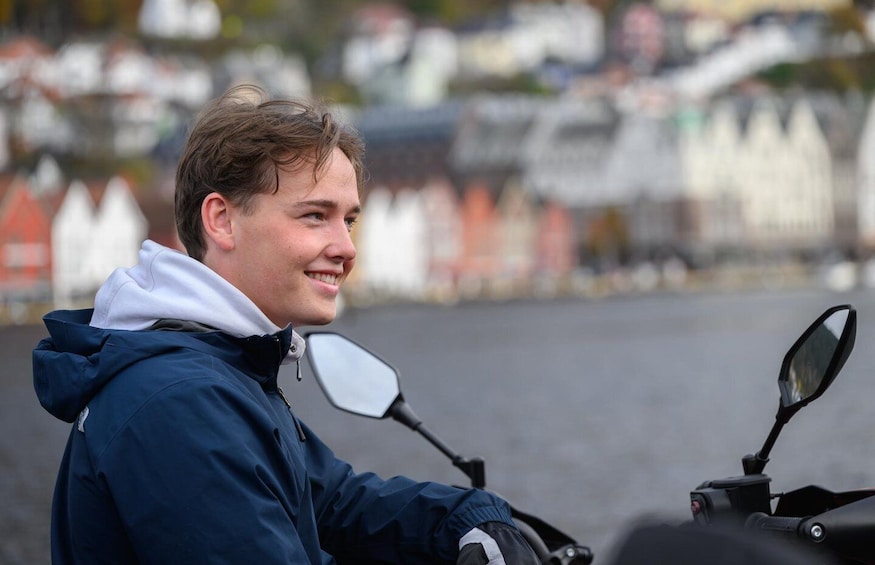 A person on a motorcycle with a cityscape in the background. 5