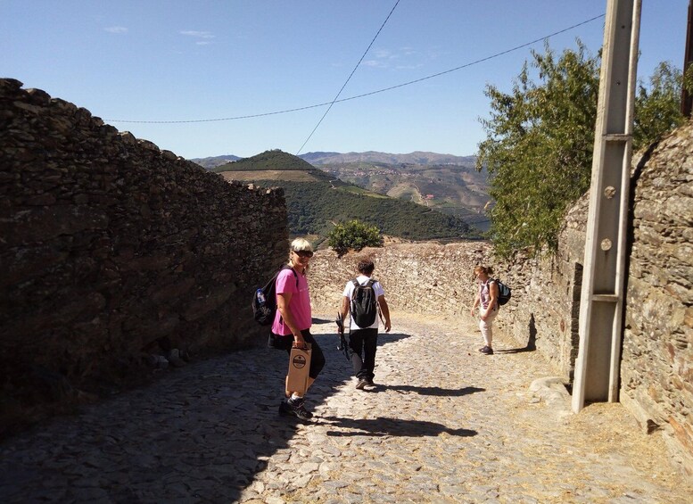 Hikers walking on a stone path with a mountainous landscape in the background. 3