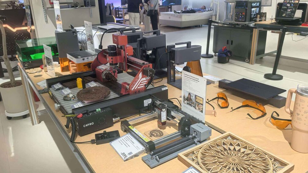 A CNC machine with a red component, a laser cutting machine, and a display of laser-cut wood patterns. 5