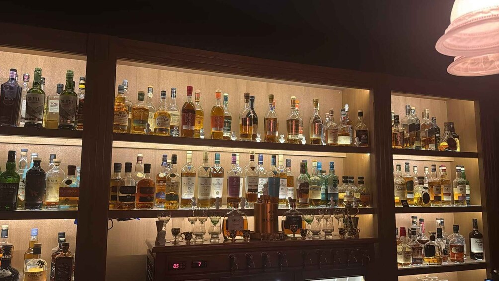 A bar with shelves of liquor bottles and glasses. 1