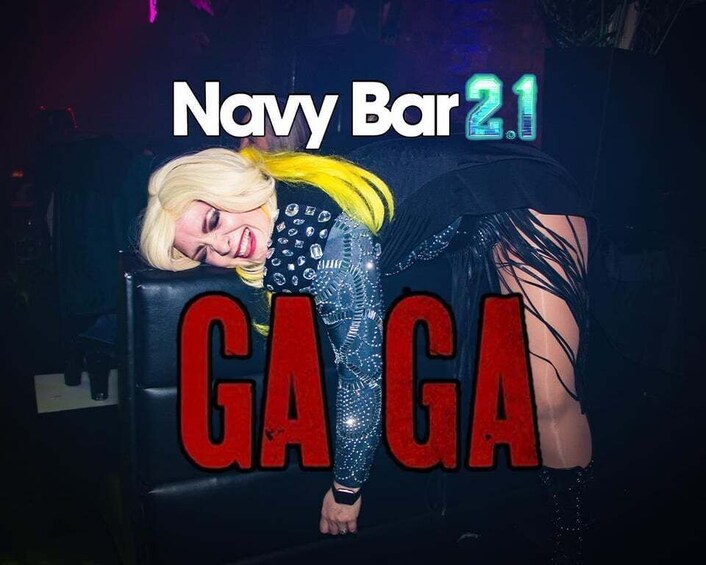 A person in a black and yellow outfit with the text 'Navy Bar 2.1' and 'GAGA' on a dark background. 2