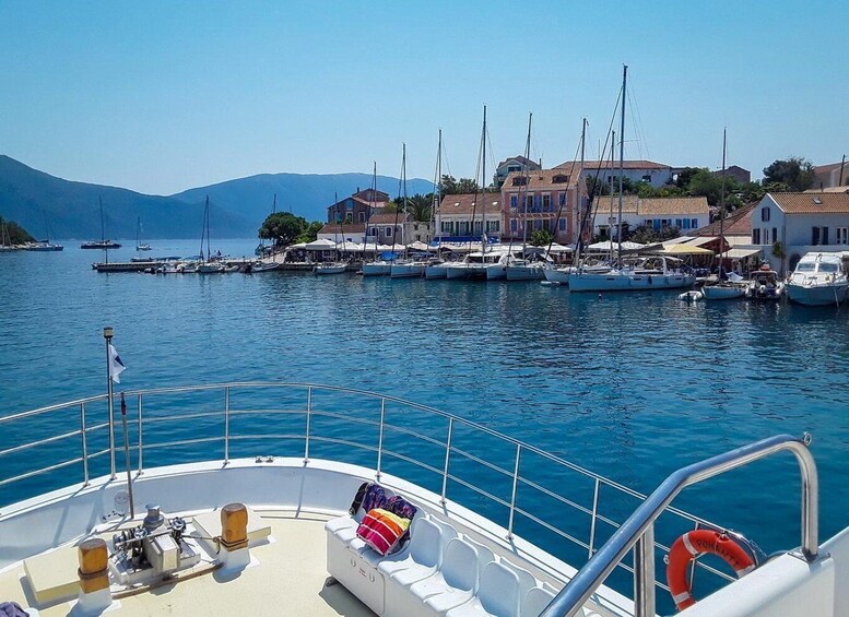 A boat docked at a marina with houses and mountains in the background. 3