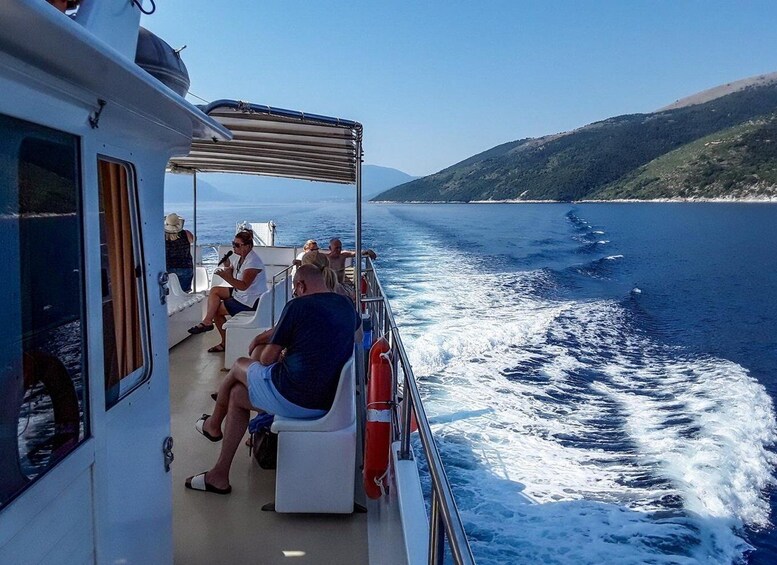 A boat with passengers enjoying the view of the sea and a distant coastline. 5