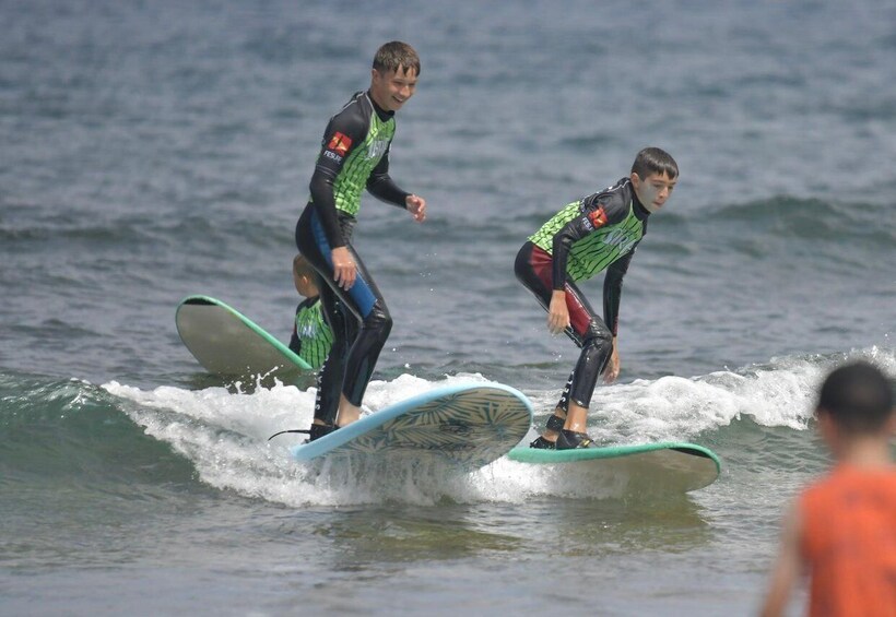Two individuals surfing on a wave in the ocean. 1