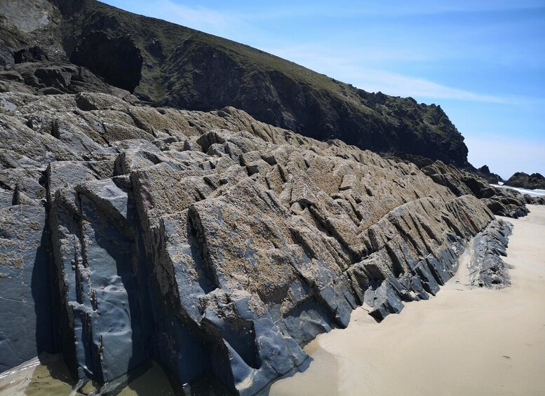 A rocky coastline with a sandy beach and a steep cliff. 3