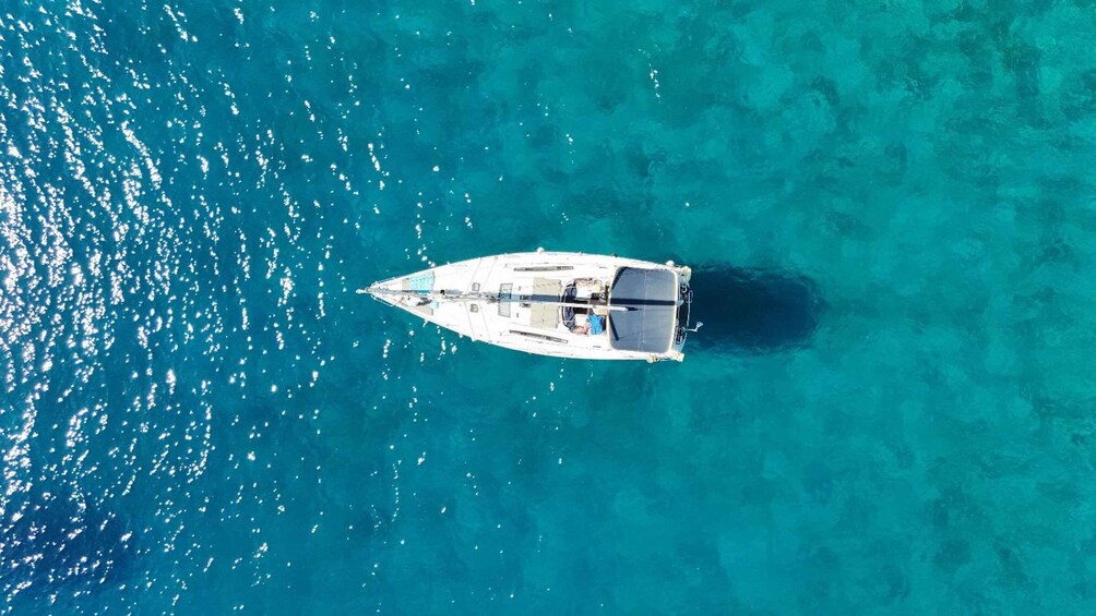 A white boat anchored in clear turquoise waters. 5