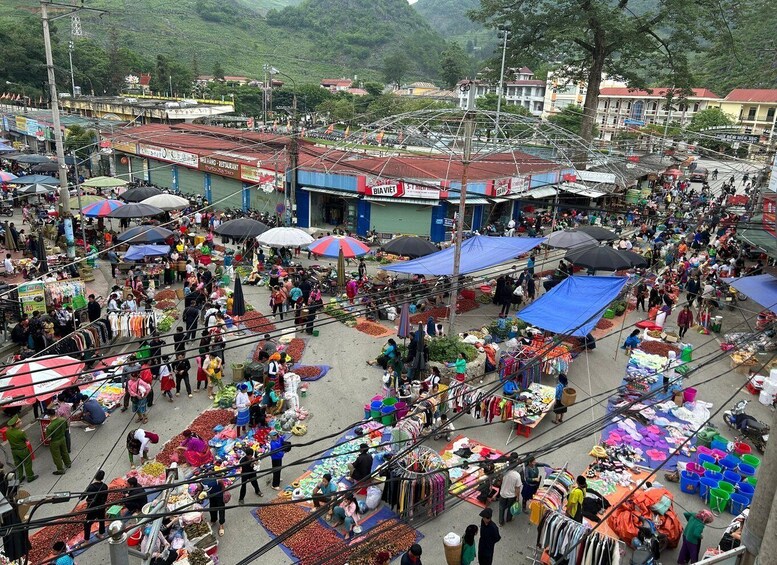 A bustling outdoor market with various stalls selling fruits, vegetables, and clothing. 4