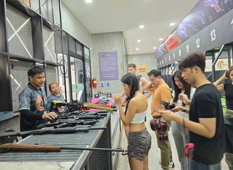 A shooting range with multiple firearms and participants. 2