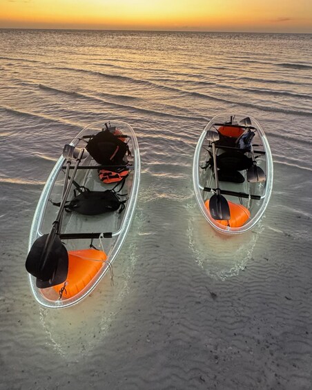 Two kayaks on a sandy beach with the ocean in the background. 1