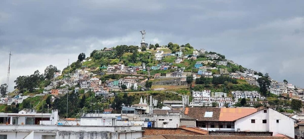 A hillside settlement with buildings, a statue, and a church. 3
