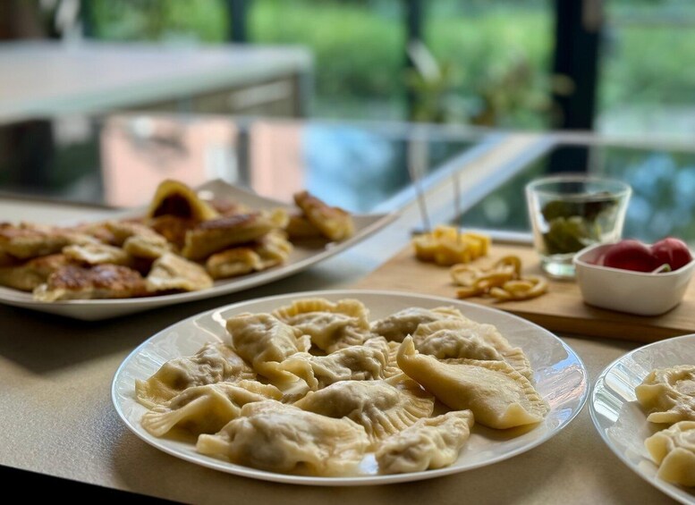 A table with plates of dumplings and a bowl of fruit. 5