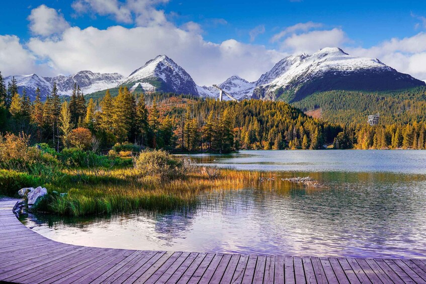 A lake surrounded by autumn-colored trees and snow-capped mountains. 2