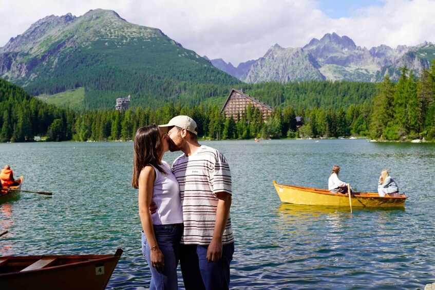 A couple embracing by a lake with mountains in the background. 3