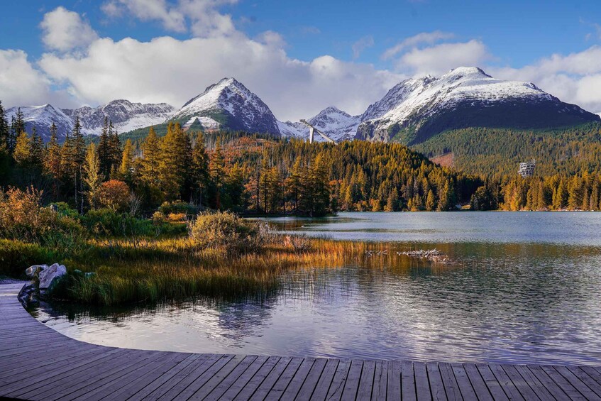 A lake surrounded by autumn-colored trees and snow-capped mountains. 2