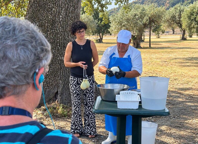 A person in a white chef's hat and blue apron preparing food outdoors with a large metal bowl and a small white bag. 5