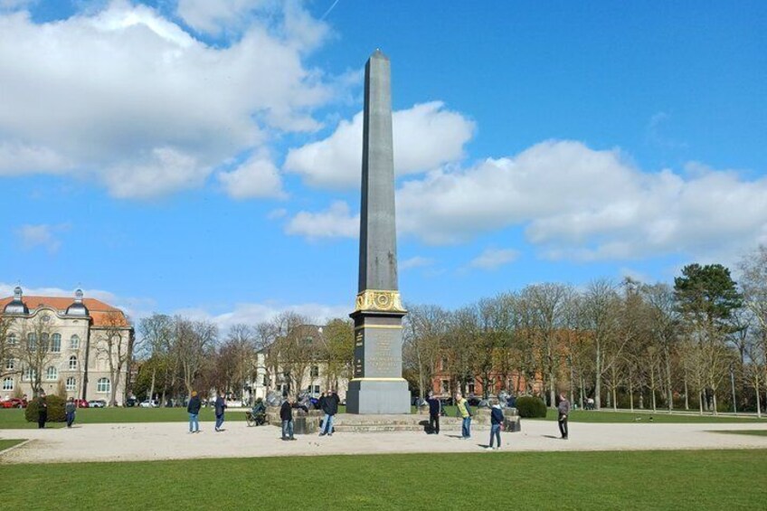 A tall monument in a park with people around it. 4