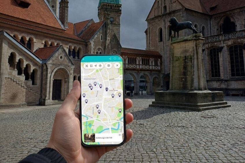 A hand holding a smartphone with a map application, a historic building with a lion statue, and cobblestone pavement. 1