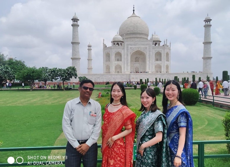 A group of people standing in front of the Taj Mahal. 1