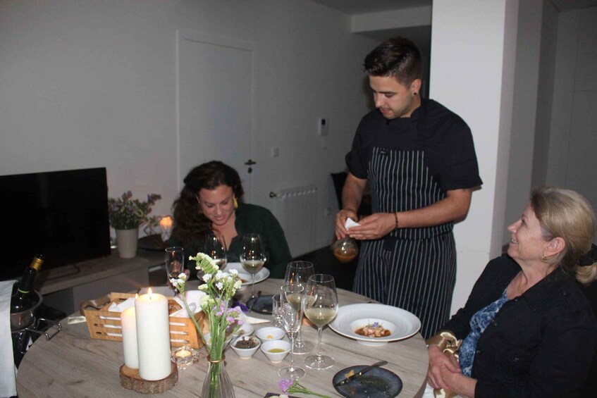 A dining table with candles, wine glasses, and plates of food. 4