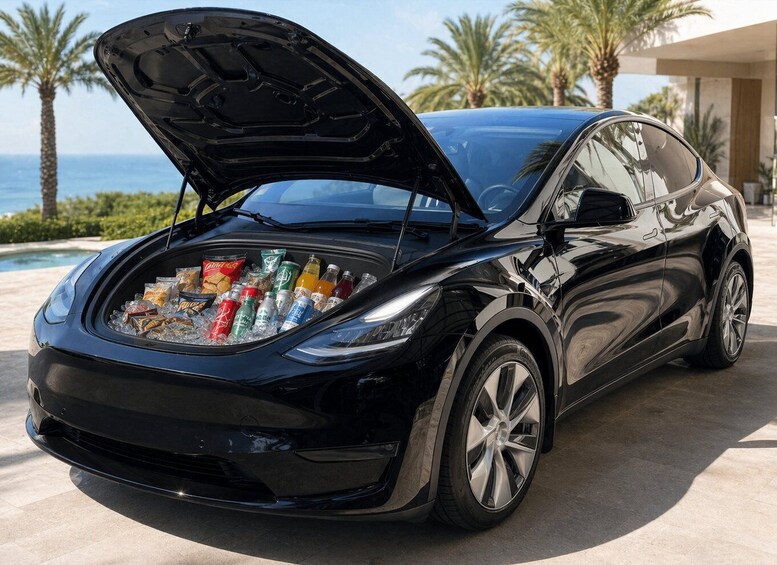 A black car with its trunk open, filled with beverages and snacks. 2