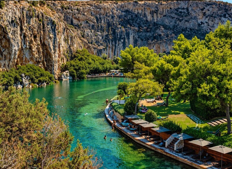 A river with clear water, surrounded by cliffs and trees, with a dock and lounge chairs. 5