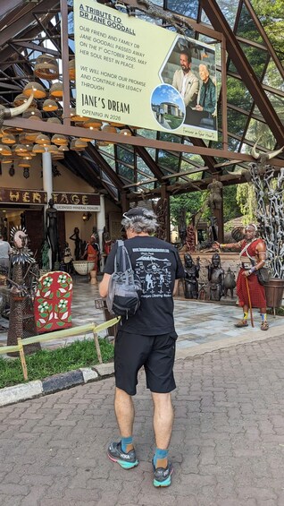 Une personne passe devant un panneau commémoratif dédié à Jane Goodall, une boutique vendant des minéraux et divers objets d’artisanat culturel. 5
