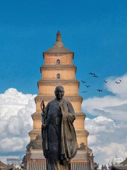 A statue in front of a pagoda with birds flying in the background. 1